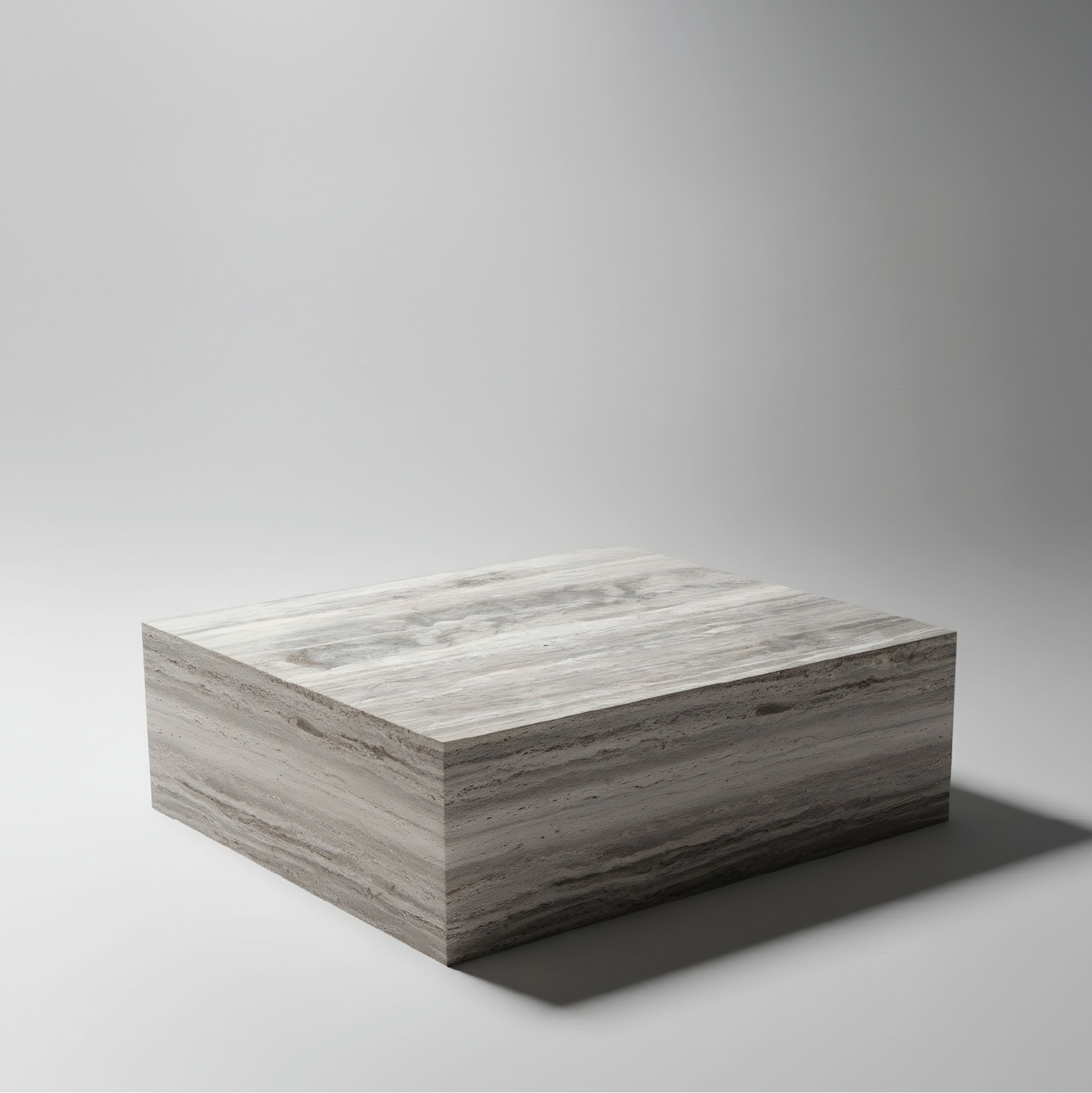 Mesa centro The Cube en travertino plata, diseño monolítico de piedra natural, acabado pulido suave.