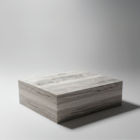 Mesa centro The Cube en travertino plata, diseño monolítico de piedra natural, acabado pulido suave.