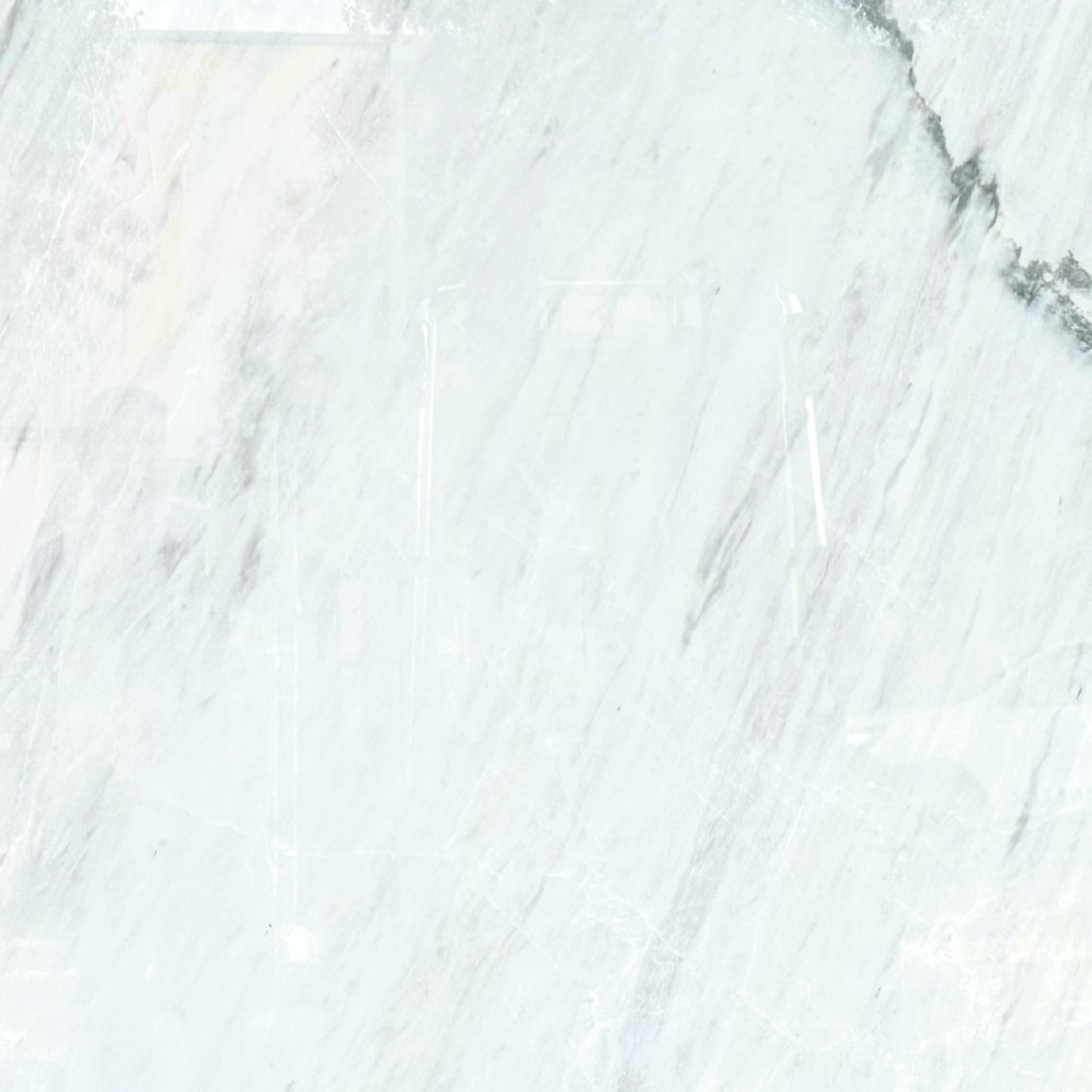 Detalle del mármol Blanco Aramis mostrando vetas suaves en tonos blancos y grises.