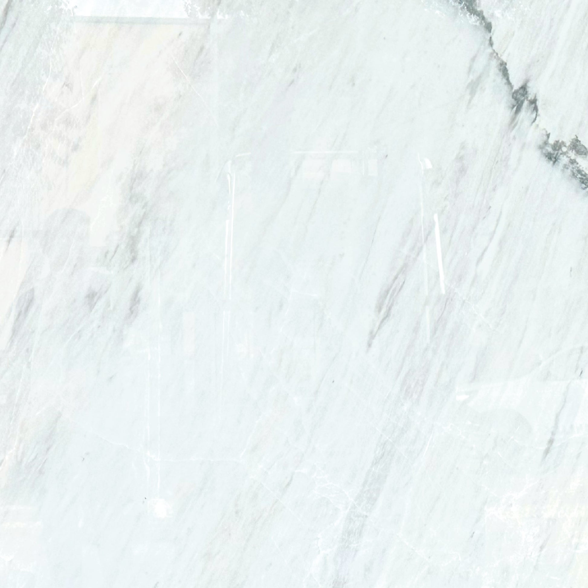 Detalle del mármol Blanco Aramis mostrando vetas suaves en tonos blancos y grises.