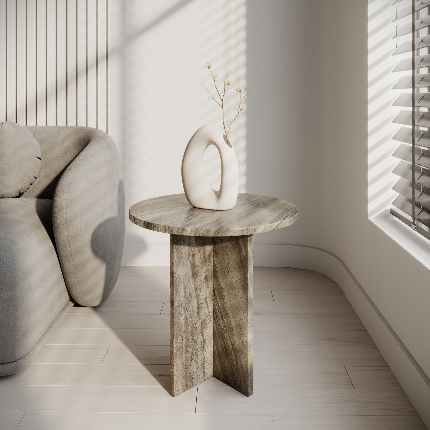 Mesa auxiliar redonda de travertino plata natural con base cruzada, diseño minimalista artesanal hecha en España.
